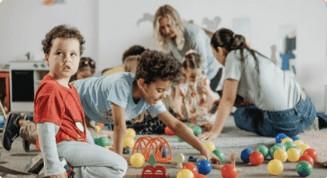 Children playing together on a classroom floor